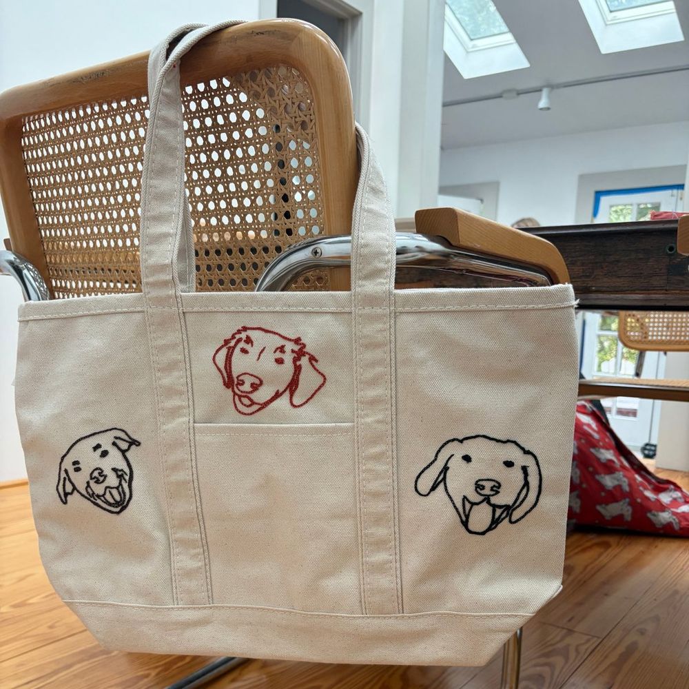 A canvas tote with three dogs chainstitched on it